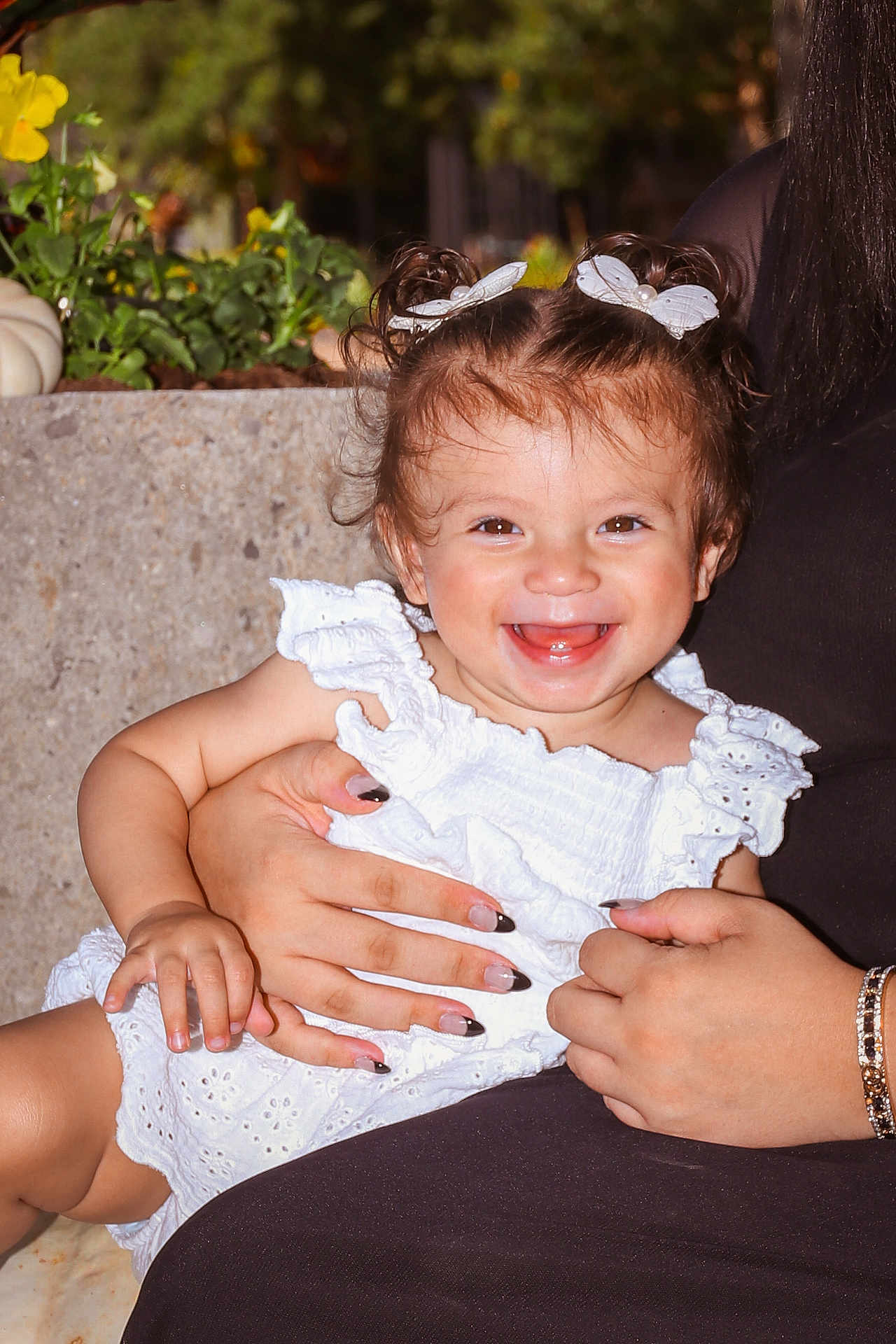 Alorah is registered to the contest to win money with this photo: toddler, child, smiling, happy, white_dress, hair_clips, butterfly, adult_hand, bracelet, nail_art, outdoor, flower, greenery, portrait, baby, cute, holding, people, skin, closeup