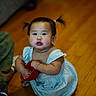 toddler, child, pigtails, blue_dress, wooden_floor, red_bowl, curious, indoors, person, baby, cute, sitting, floor, hand, skin, face, expression, young_child, casual, home