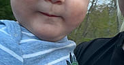 Alex joined the competition — help win amazing prizes! adult, baby, casual, cheeks, child, closeup, clothing, dinosaur_graphic, face, glasses, head, holding, nature, outdoor, person, portrait, sky, striped_shirt, text_on_clothing, trees