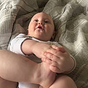 Alex is registered to the contest to win money with this photo: baby, blanket, casual, child, cozy, cute, expression, foot, hand, happy, indoor, infant, legs, lying_down, one_person, patterned_blanket, playful, skin, white_clothing, young