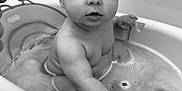 Theo is registered to the contest to win money with this photo: baby, infant, bathtub, bath_time, water, child, face, big_eyes, wet_hair, mohawk, chubby_arm, sitting, portrait, closeup, bath_seat, bubbles, bathroom, looking_at_camera, cute, skin