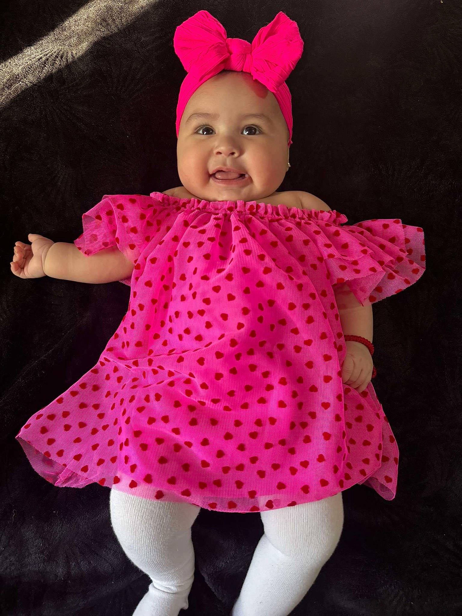 Lila is registered to the contest to win money with this photo: arm, baby, baby_toddler_clothing, cap, child, costume_hat, dress, face, happy, headgear, headwear, magenta, outerwear, pattern, person, pink, purple, sleeve, smile, thumb