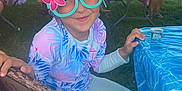 Malak joined the competition — help win amazing prizes! child, girl, glasses, novelty_glasses, flower, parrot, outdoor, party, picnic, table, chair, grass, people, sunny, smile, colorful, clothing, fun, nature, event