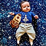 baby, infant, child, blanket, space_theme, rocket, wooden_sign, blue_shirt, pants, socks, lying_down, stars, planets, moon, cute, portrait, indoors, young_child, comfortable, adorable