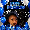 1st_birthday, baby, background, balloons, birthday, blue_suit, celebration, child, cute, decorations, earrings, event, face, fedora, festive, hat, party, portrait, smiling, tie