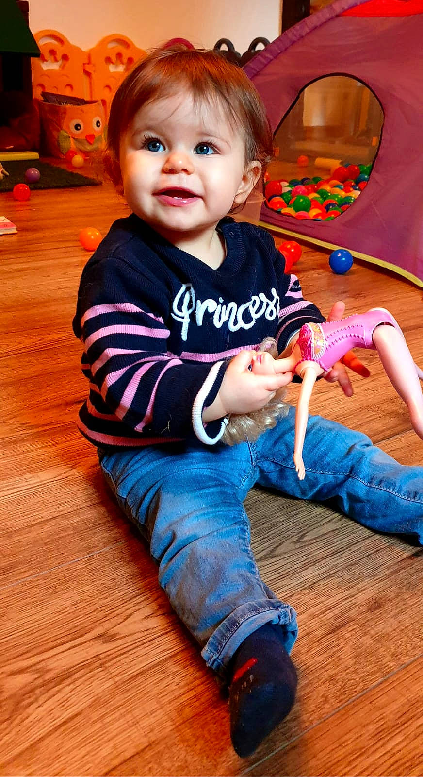 Emmy participe au concours pour gagner de l'argent avec cette photo : baby, baby_toddler_clothing, cheek, child, eye, flooring, fun, hair, happy, hardwood, head, iris, leg, person, sitting, skin, sleeve, smile, t_shirt, toddler