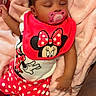 Hera joined the competition — help win amazing prizes! baby, sleeping, pacifier, pink_blanket, minnie_mouse, red_clothing, polka_dots, infant, cute, child, soft_texture, cozy, resting, toddler, clothing, indoor, person, cute_outfit, baby_bib, relaxation