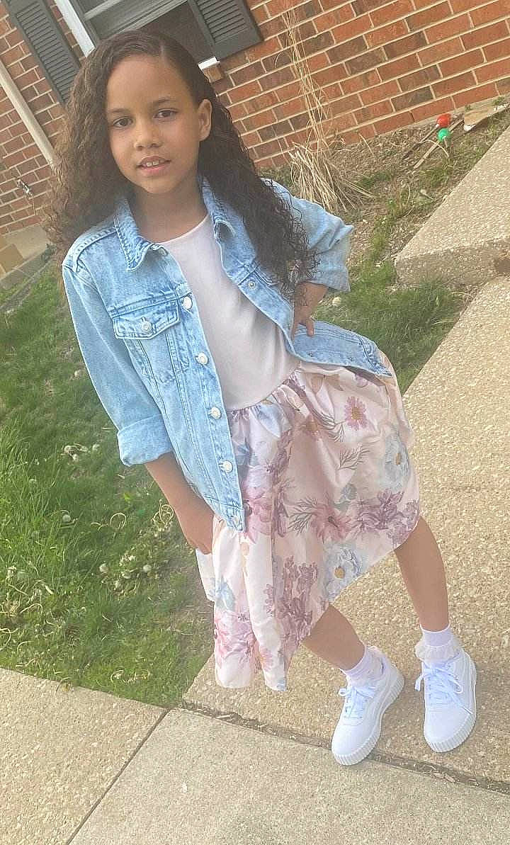 Audriana joined the competition — help win amazing prizes! bangs, brown_hair, child, denim, dress_shirt, face, fashion_design, grass, hairstyle, human_leg, joy, leg, lip, long_hair, pattern, person, pink, sitting, skin, sleeve