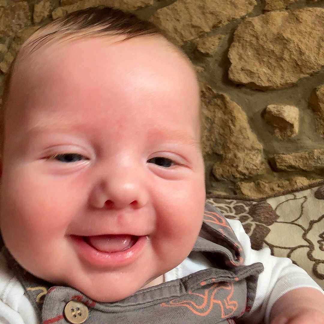 Anthony Jr is registered to the contest to win money with this photo: apparel, baby, child, closeup, clothing, cushion, cute, expression, face, hand, happy, indoors, infant, pattern, person, portrait, sitting, smiling, stone_wall, young