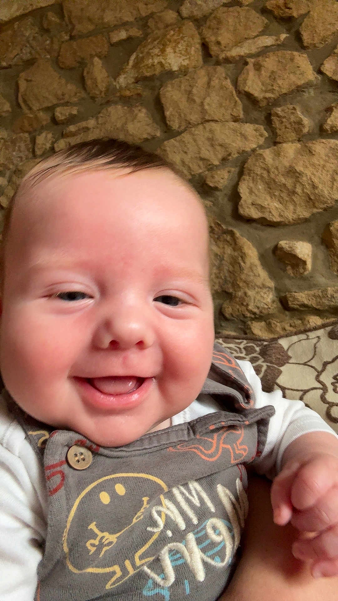 Anthony Jr is registered to the contest to win money with this photo: baby, smiling, face, infant, child, clothing, pattern, stone_wall, cushion, happy, portrait, closeup, hand, indoors, young, cute, expression, person, sitting, apparel