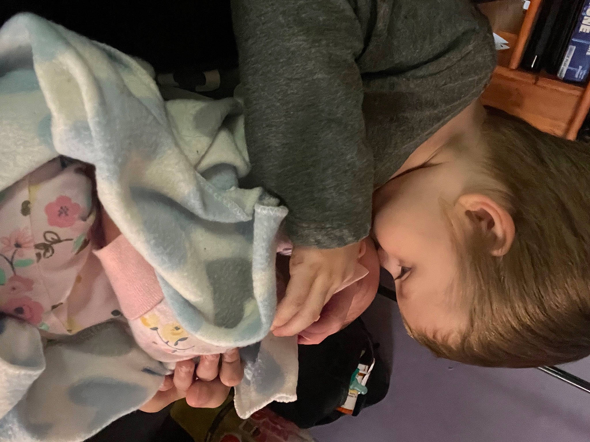 Dean is registered to the contest to win money with this photo: baby, baby_products, bookcase, cheek, child, comfort, ear, eyelash, finger, gesture, hand, happy, human_body, mouth, nail, person, shelf, sitting, skin, thumb