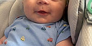 Tommy joined the competition — help win amazing prizes! baby, infant, smile, onesie, car_prints, baby_carrier, cushion, soft_texture, happy, portrait, child, cute, closeup, person, indoor, skin, face, eyes, arm, clothing