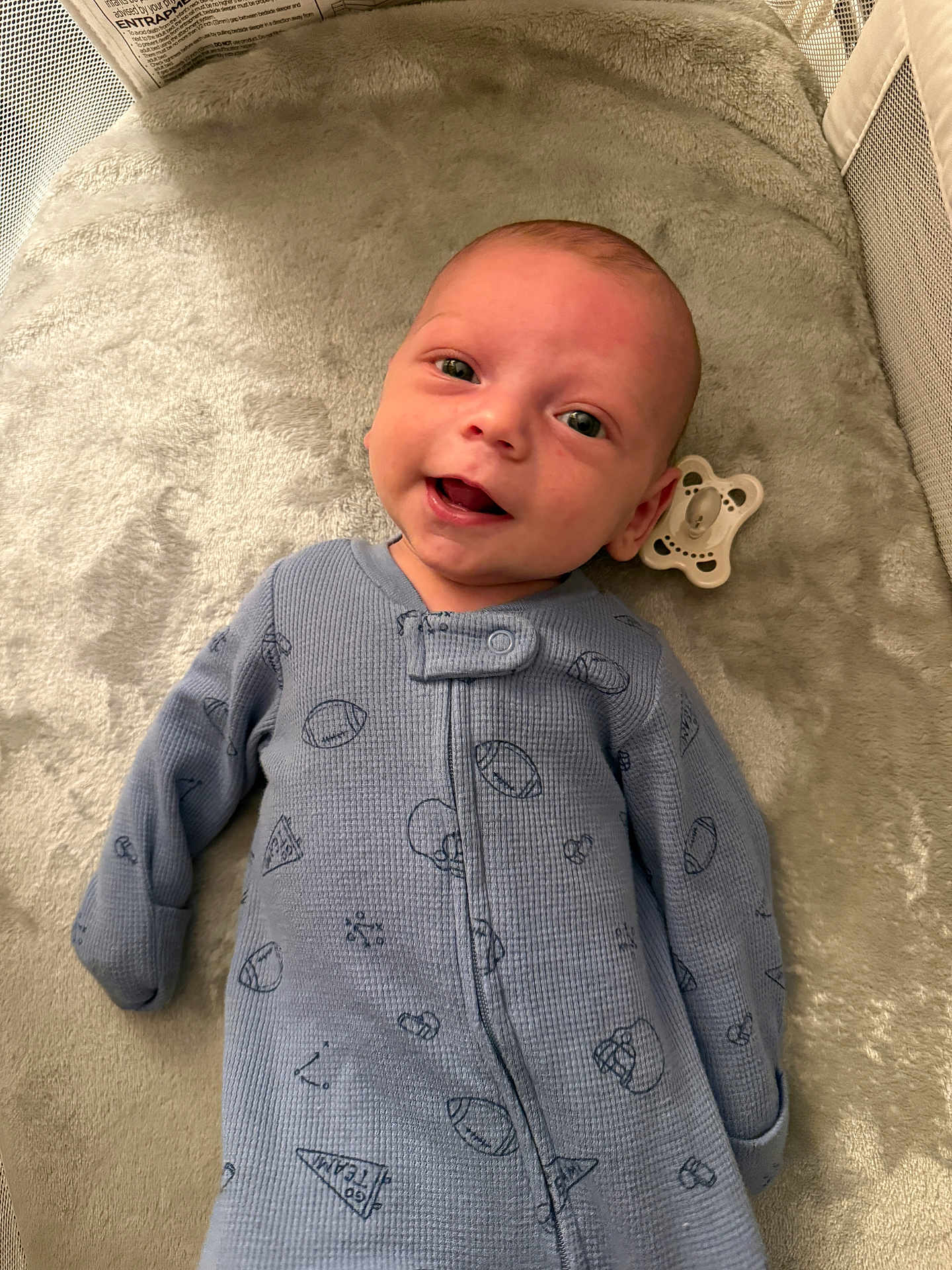 Jett joined the competition — help win amazing prizes! baby, infant, smiling, blue_onesie, crib, blanket, pacifier, face, happy, lying_down, child, cute, indoor, soft_texture, newborn, person, sleepwear, cozy, closeup, head