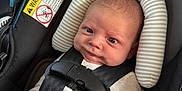 Jett joined the competition — help win amazing prizes! baby, car_seat, infant, seat_belt, pacifier, striped_pillow, black_straps, beige_clothing, face, head_support, child, safety, cute, indoors, closeup, newborn, expression, secure, comfort, car_interior