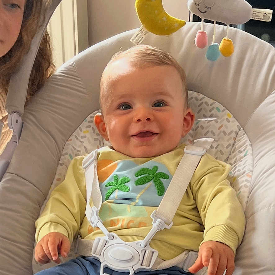 Louis participe au concours pour gagner de l'argent avec cette photo : baby, baby_rocker, child, clothing, cloud, face, floor, footwearless, happy, headband, indoor, infant, mobile, moon, pants, person, seat, smiling, sweater, toy