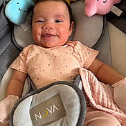 Ines joined the competition — help win amazing prizes! baby, infant, child, smiling, happy, portrait, car_seat, plush_toys, stuffed_animals, cloud_toy, sun_toy, pink_clothing, blanket, harness, seated, indoor, close_up, face, toy, photography
