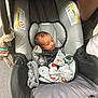 newborn, baby, car_seat, infant, onesie, plush_toy, gray, seatbelt, cute, indoors, person, child, sitting, cozy, clothing, pacifier, fabric, soft, small, wrapped