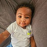 D'Montae joined the competition — help win amazing prizes! baby, child, toddler, infant, person, face, eyes, smile, clothing, tshirt, logo, nike, couch, furniture, indoor, skin, hair, curly_hair, comfort, relaxing