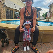 D'Montae joined the competition — help win amazing prizes! adult, toddler, child, woman, smiling, plaid_outfit, hat, sunglasses, jewelry, fountain, outdoor, shopping_center, pavement, stroller, people, sunny, daytime, holding_hands, casual_clothing, footwear