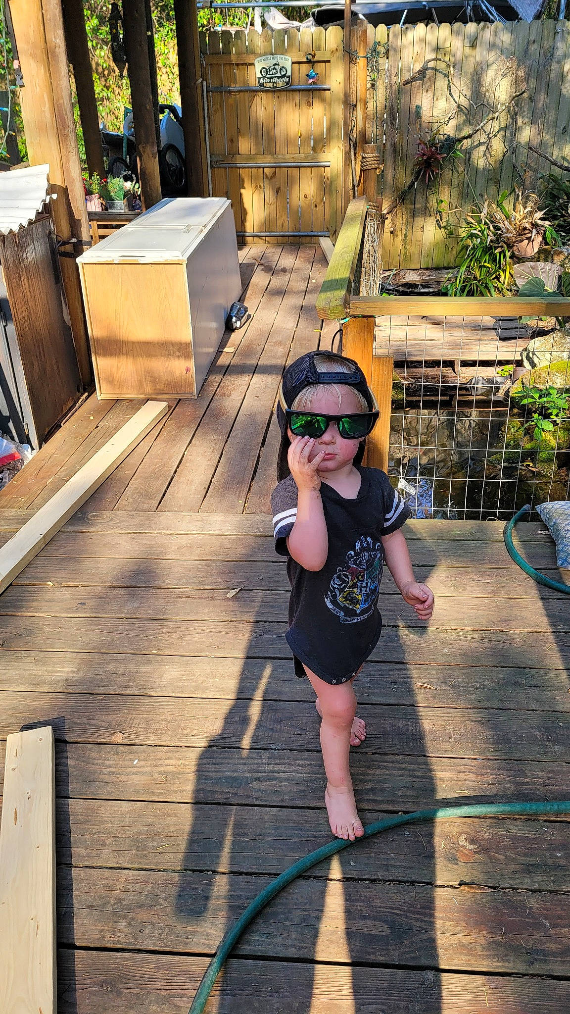 Paul is registered to the contest to win money with this photo: asphalt, baseball_cap, cap, city, eyewear, flooring, fun, happy, hat, headwear, human_leg, leisure, person, plant, recreation, road_surface, sidewalk, sun_hat, sunglasses, toddler