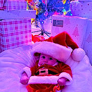Rowan is registered to the contest to win money with this photo: baby, infant, santa_costume, christmas_tree, christmas_lights, gifts, wrapped_presents, holiday, festive, red_clothing, white_fur_trim, hat, blanket, indoor, cute, child, celebration, holiday_decorations, smiling, festivity