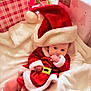 Rowan is registered to the contest to win money with this photo: baby, child, christmas, holiday, santa_hat, santa_costume, blanket, gift, present, christmas_tree, festive, cute, indoors, holiday_decor, infant, white_blanket, red_clothing, sock, holiday_season, celebration