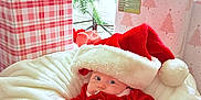 Rowan joined the competition — help win amazing prizes! baby, santa_hat, christmas_tree, presents, holiday, festive, blanket, red_clothing, white_fur, decorations, gift_wrap, celebration, cute, infant, indoors, holiday_season, christmas, soft_texture, smiling, warm