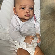 Sheryfa participe au concours pour gagner de l'argent avec cette photo : baby, infant, child, bouncer, onesie, bib, pillow, skin, legs, hands, eyes, serious_expression, dark_eyes, indoor, wooden_floor, beads, teether, portrait, sitting, cute