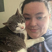 Violet is registered to the contest to win money with this photo: cat, person, selfie, cuddling, pet, gray_cat, white_paws, whiskers, sleepy, relaxed, closeup, portrait, indoor, home, window_light, human_face, smiling, nose_ring, casual, affection