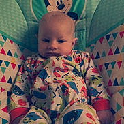 Jackson joined the competition — help win amazing prizes! baby, infant, onesie, colorful_clothing, mickey_mouse, baby_seat, patterned_fabric, indoor, child, cute, smiling, person, young_child, seated, plush_seat, cartoon_character, comfort, relaxed, portrait, baby_clothes