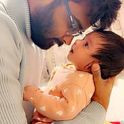 Sehrish joined the competition — help win amazing prizes! baby, man, glasses, beard, holding, face, love, intimacy, closeup, indoor, sweater, heart_pattern, child, parent, affection, portrait, person, warm_light, cuddling, family