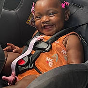 Zailynn joined the competition — help win amazing prizes! baby, child, car_seat, smiling, happy, hair_clips, orange_clothing, seatbelt, infant, cute, safety, car_interior, portrait, young_child, child_safety, baby_girl, seat, straps, fun, joyful
