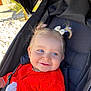 Lola a rejoint le concours — aidez-le/la à gagner de superbes lots ! baby, baby_girl, blue_eyes, child, closeup, clothing, cute, face, hair_bows, happy, infant, outdoor, person, pigtails, portrait, red_sweater, seat, smile, stroller, sunlight