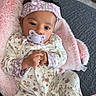 Mariam joined the competition — help win amazing prizes! baby, infant, child, portrait, pacifier, headband, floral_clothing, onesie, smiling, sitting, lying_down, indoor, blanket, pink_blanket, cushion, sofa, rug, home, close_up, cozy