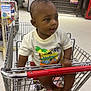 Kaleb joined the competition — help win amazing prizes! aisle, baby, casual_clothing, child, curious, floor, footwear, greeting_cards, indoor, metal, person, retail, shopping, shopping_cart, sitting, snacks, store, toddler, tshirt, young_child