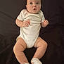baby, infant, child, onesie, socks, lying_down, curious, chubby, cute, soft_lighting, blanket, indoor, portrait, skin, hands, legs, feet, face, head, expression