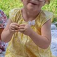 Amnnesya a rejoint le concours — aidez-le/la à gagner de superbes lots ! child, girl, glasses, yellow_dress, sitting, outdoor, grass, snack_bag, blanket, happy, smiling, curly_hair, person, summer, playful, cute, young, casual, daytime, relaxed