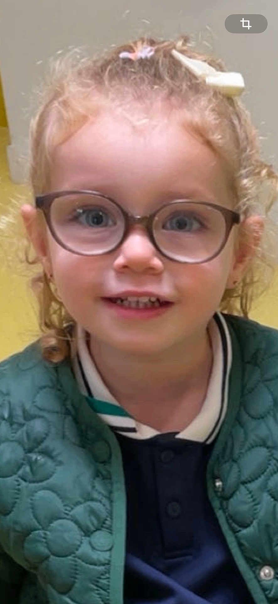 Amnnesya participe au concours pour gagner de l'argent avec cette photo : child, glasses, curly_hair, smile, jacket, green_jacket, portrait, face, young, casual_clothing, indoor, person, cute, eyewear, happy, head, hair_accessory, buttoned_jacket, closeup, fashion