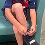 Amnnesya participe au concours pour gagner de l'argent avec cette photo : child, boy, glasses, sitting, tying_shoes, sneakers, puma, jersey, sportswear, scrapes, knee, indoor, chair, floor, shorts, casual, focused, person, footwear, tying_laces