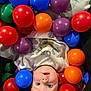 baby, child, ball_pit, colorful, plastic_balls, play, indoor, cute, face, expression, blue_eyes, white_clothing, infant, fun, leisure, happy, young, portrait, looking_up, playful