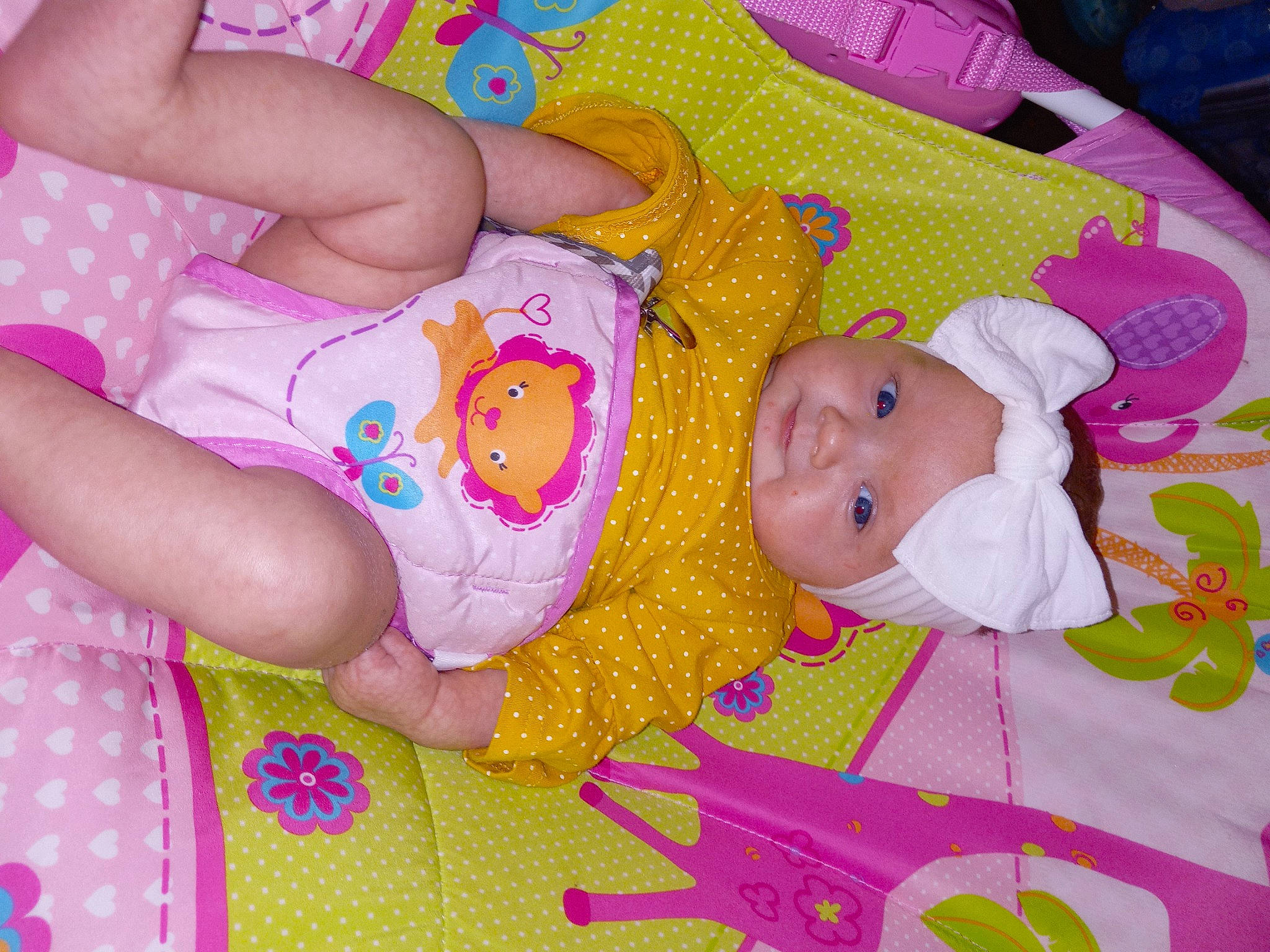 Dynver is registered to the contest to win money with this photo: baby, baby_products, baby_toddler_clothing, cheek, child, comfort, face, facial_expression, happy, head, headwear, linens, magenta, nail, pattern, person, pink, room, skin, textile