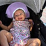 Addison joined the competition — help win amazing prizes! baby, child, smiling, stroller, hat, purple_hat, pink_outfit, floral_pattern, sunlight, happy, infant, cute, outdoor, baby_clothing, legs, face, person, seat, striped_canopy, relaxing