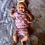 Addison is registered to the contest to win money with this photo: baby, smiling, purple_outfit, daisies, headband, bow, blanket, lying_down, happy, infant, cute, child, soft_texture, indoors, feet, arms, face, person, clothing, playful