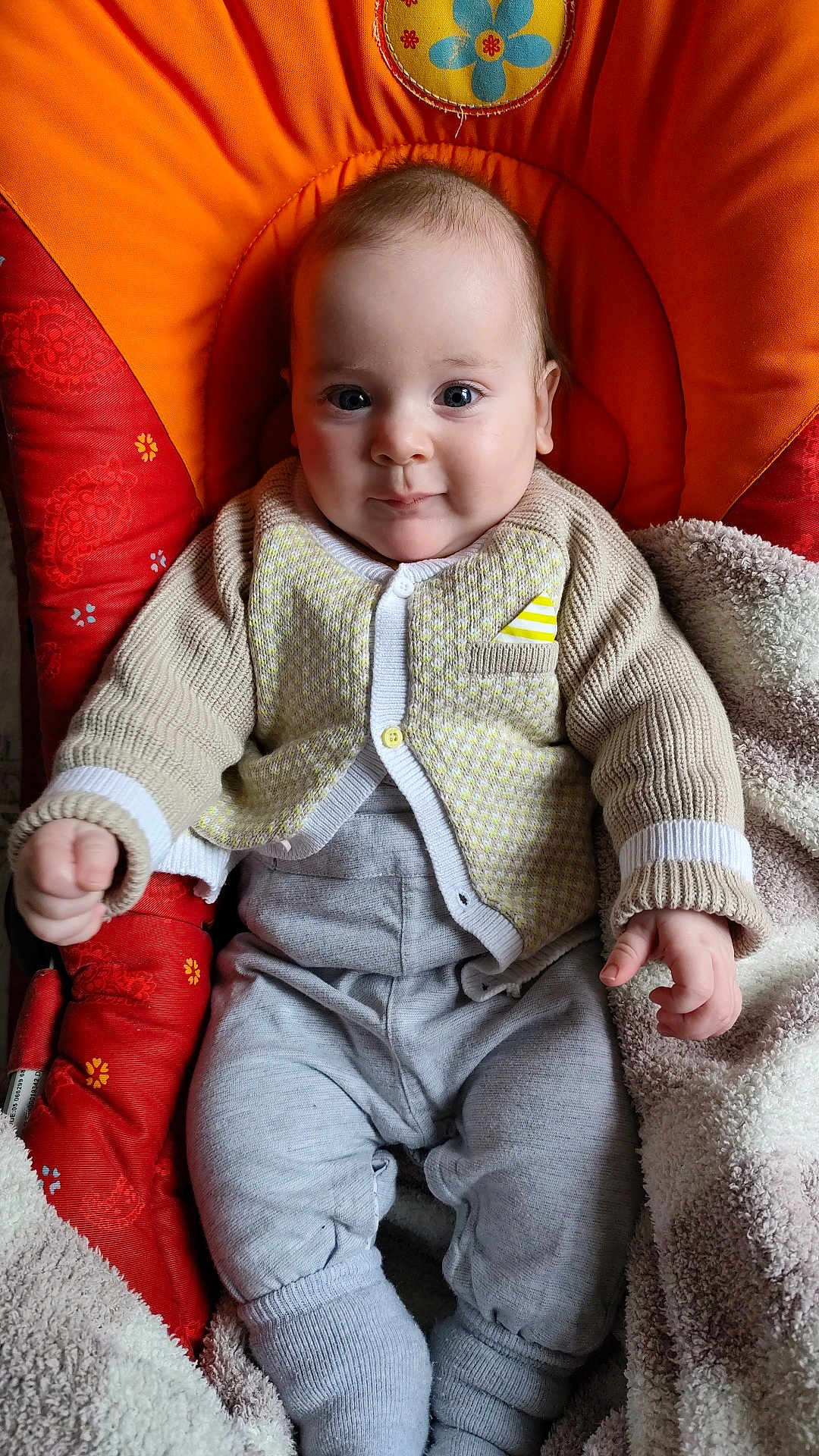 Gabriel participe au concours pour gagner de l'argent avec cette photo : baby, infant, child, knitwear, orange_cushion, blanket, cozy, seated, cute, portrait, indoor, smiling, hands, legs, warm_clothing, comfortable, soft_texture, casual, young, face