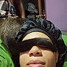 Azure is registered to the contest to win money with this photo: animal, bedroom, bonnet, cat, closeup, door, expressionless, face, furniture, green_blanket, headwear, indoor, person, pet, playful, purple_wall, relaxation, resting, skin, tail