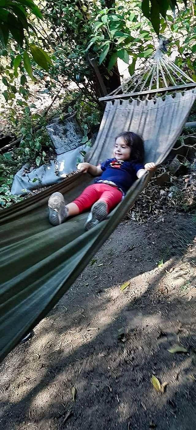 Mariana participe au concours pour gagner de l'argent avec cette photo : adventure, city, forest, fun, grass, hammock, jungle, leisure, outdoor_play_equipment, people_in_nature, person, plant, playground, recreation, shorts, sitting, swing, t_shirt, toddler, tree
