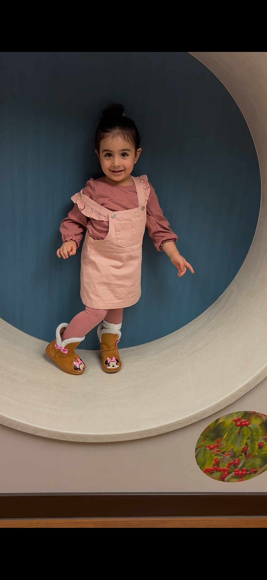Marcellina is registered to the contest to win money with this photo: boots, child, circular_frame, clothing, cute, fashion, feet, floor, girl, happy, indoor, minnie_mouse, pink_dress, playful, portrait, pose, smile, standing, wall, young_child