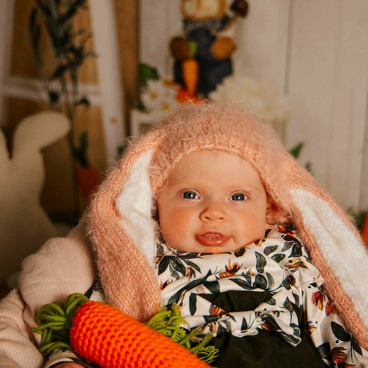 Orla joined the competition — help win amazing prizes! baby, blue_eyes, bunny_ears, bunny_figure, child, cozy, crocheted_carrot, cute, decor, face, floral_shirt, hand, indoor, knitted_hat, person, plush, portrait, smiling, soft_lighting, warm_colors