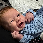 Kynoah is registered to the contest to win money with this photo: baby, infant, face, expression, blue_clothing, striped, hands, skin, hair, eyes, blanket, soft, cute, resting, portrait, young_child, indoors, cozy, child, newborn