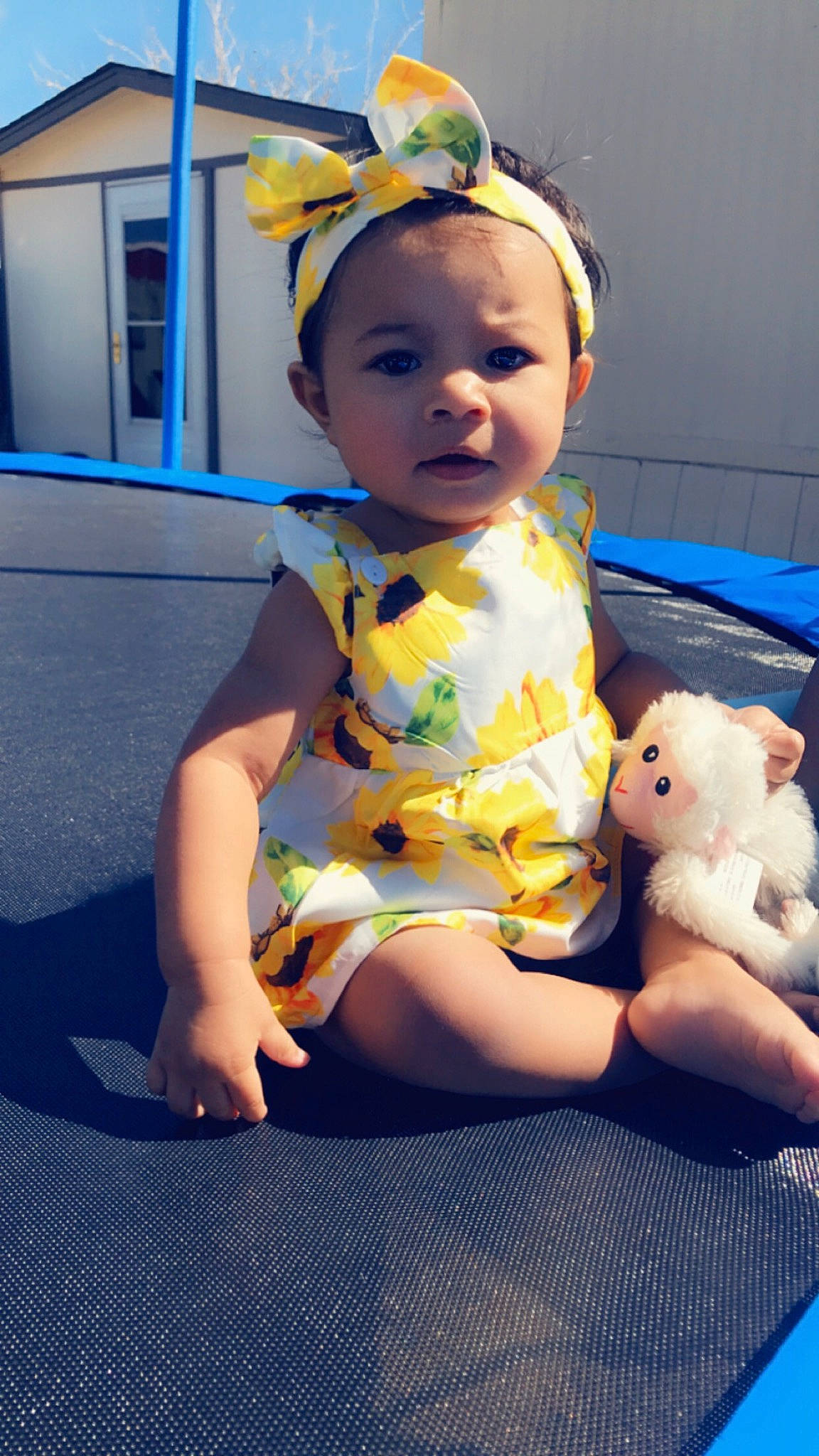 Carla is registered to the contest to win money with this photo: baby, baby_toddler_clothing, blue, child, foot, fun, goggles, grass, happy, headband, leisure, person, pink, play, recreation, sitting, skin, teddy_bear, toddler, toy